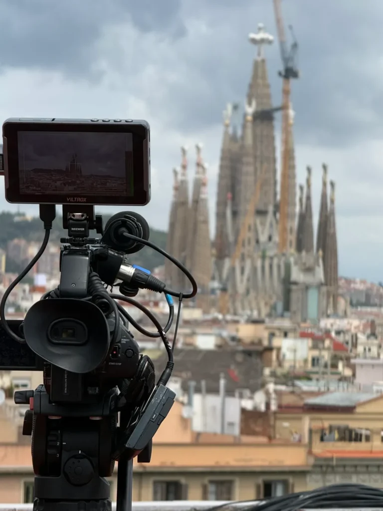 Camera crew in Barcelona filming the Sagrada Família from a rooftop