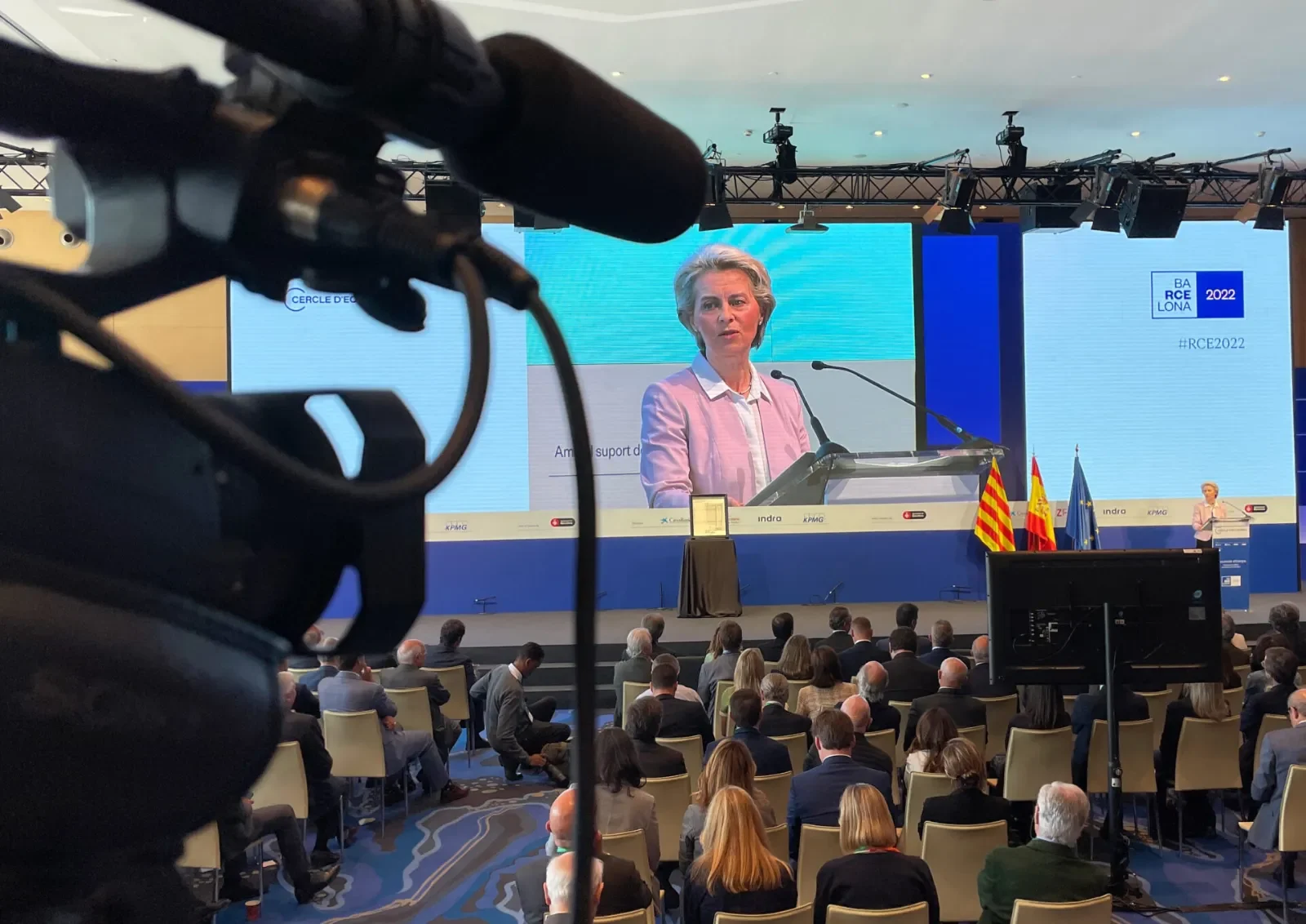 Conference videographer filming a speaker at the lectern during a corporate event