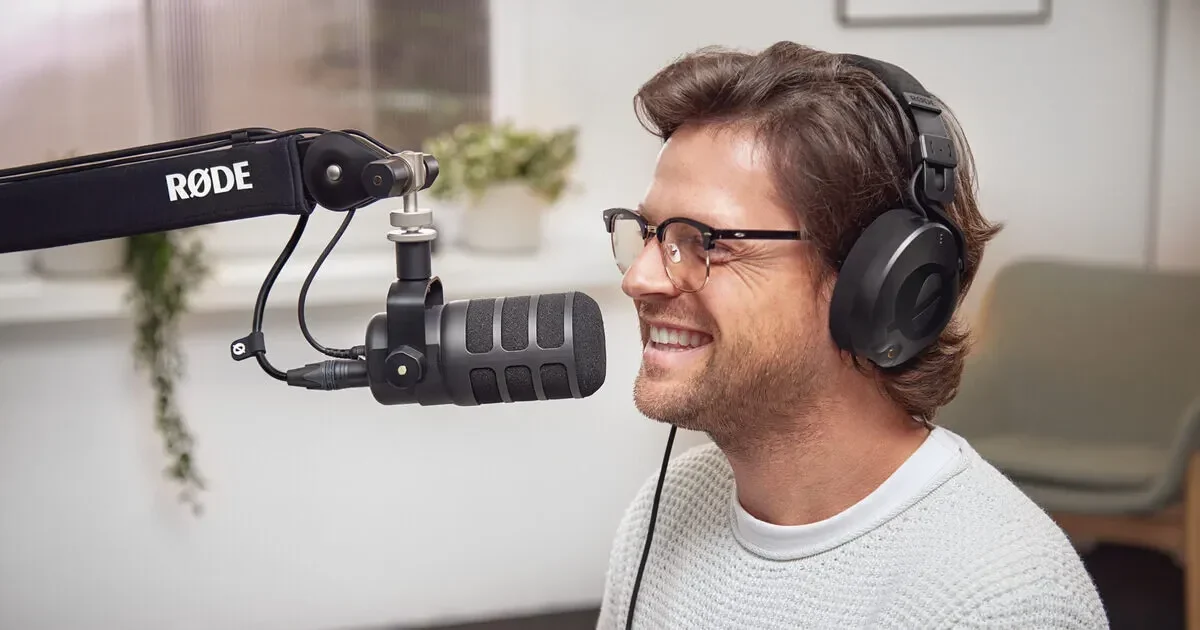 Hombre con auriculares hablando ante un micrófono de podcast montado en un brazo articulado