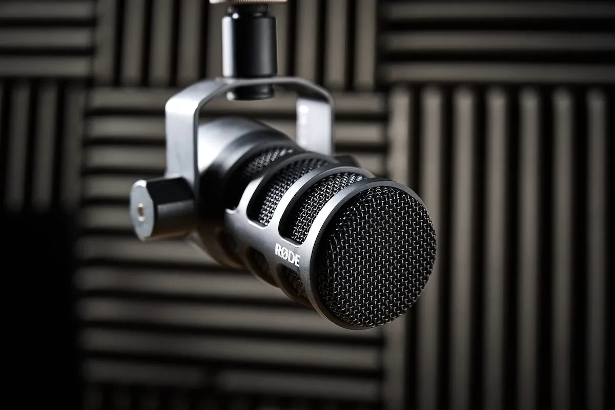 Micrófono dinámico de podcast suspendido delante de paneles acústicos negros